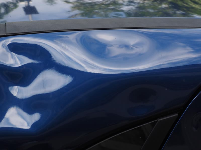 Large dent with creases in a car body panel